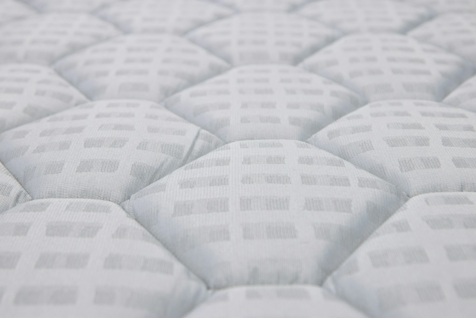 Close-up of a white quilted mattress texture